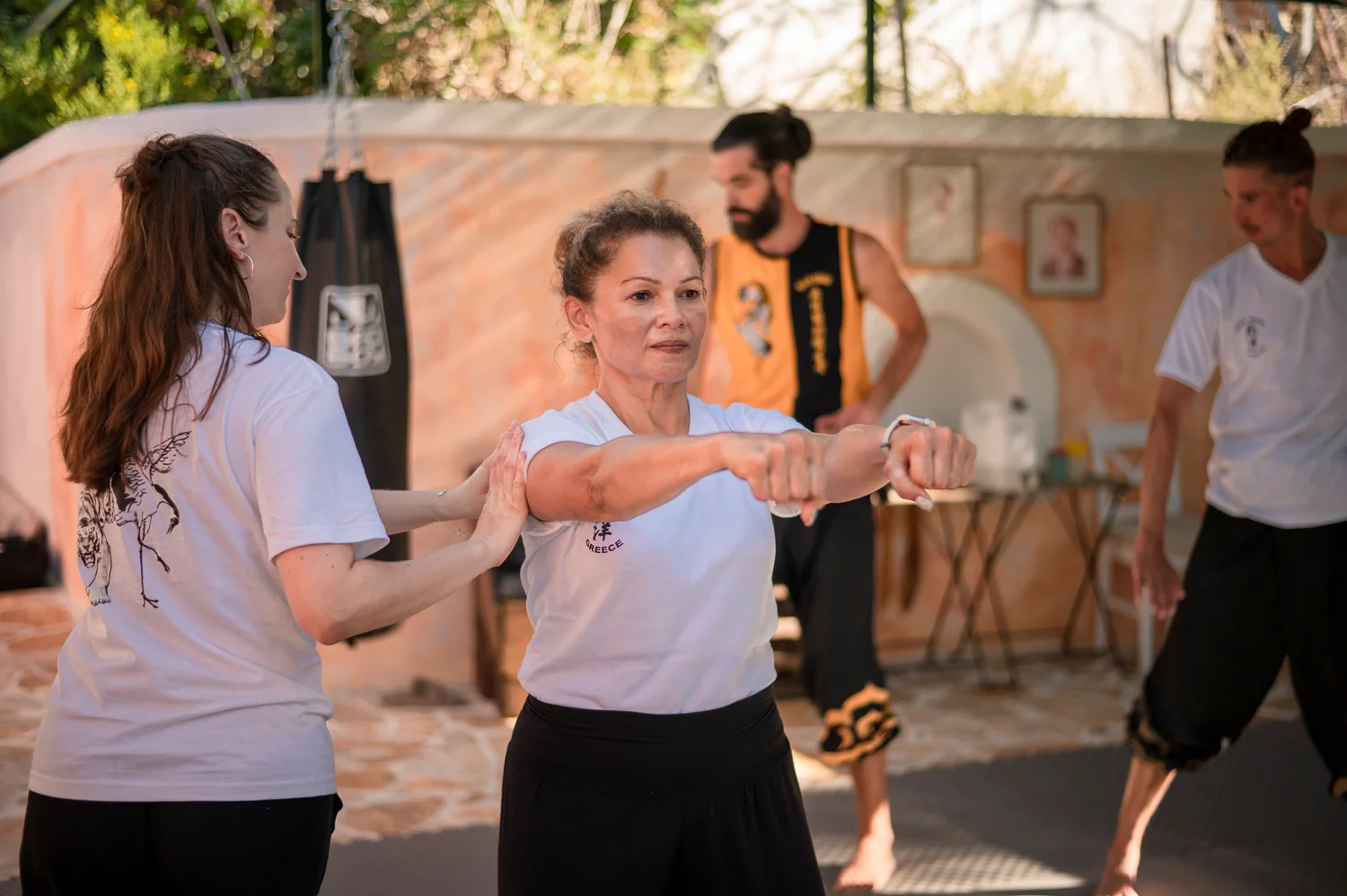 Students training together indoors with focus pads and partner drills