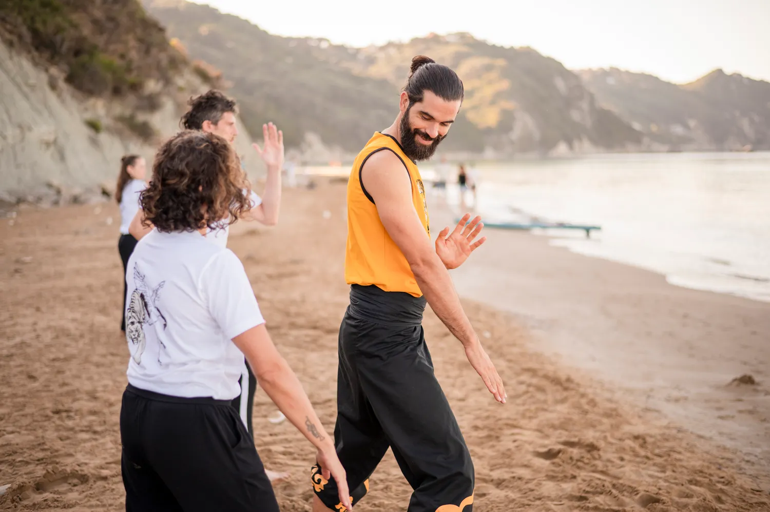 Thomas guiding students through Shuang Yang practice on Arillas beach